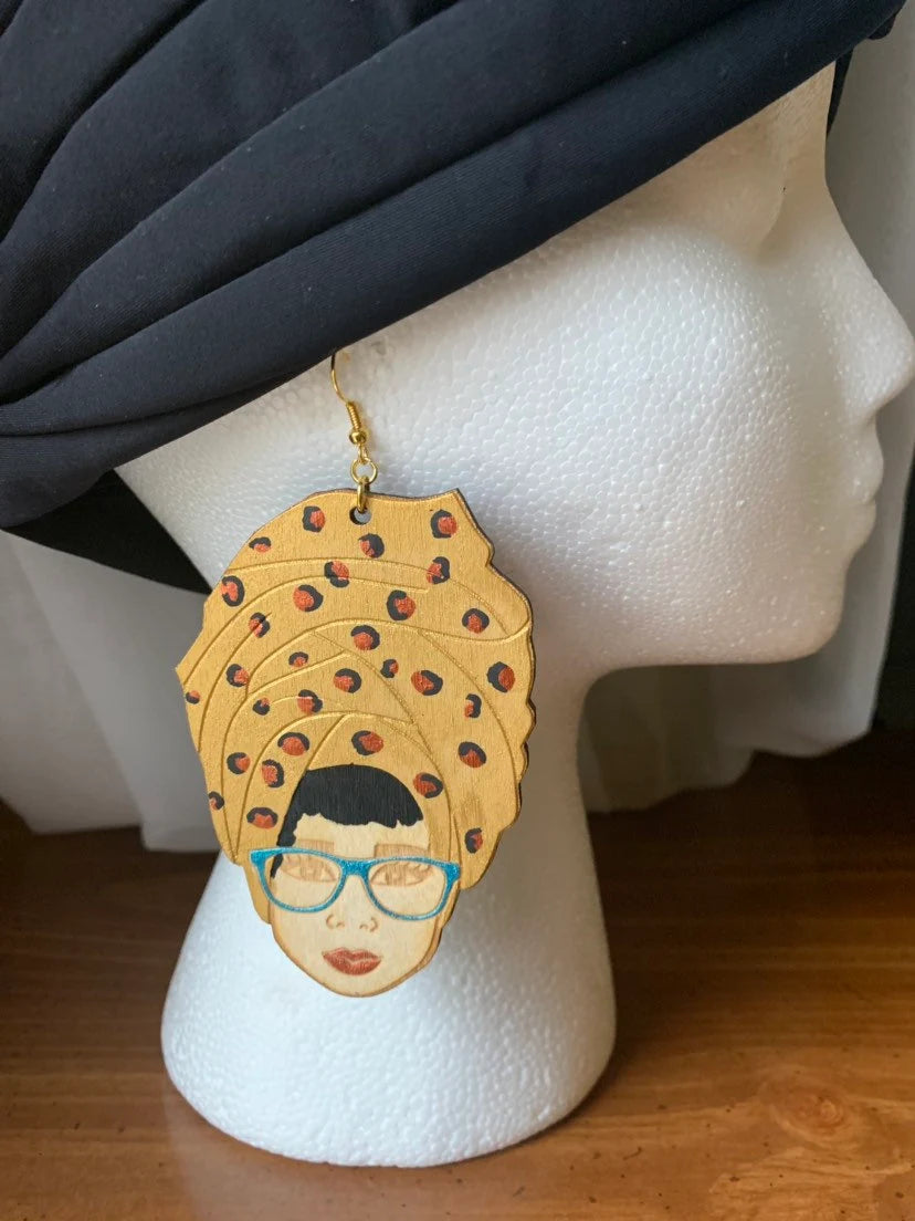 Headwrap lady with gold Leopard print head wrap, blue topaz glasses and a bronze pout wood earrings, wood earrings, Afro lady inspired